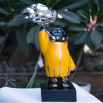 The luxury sculpture features a yellow figure carrying a cloud